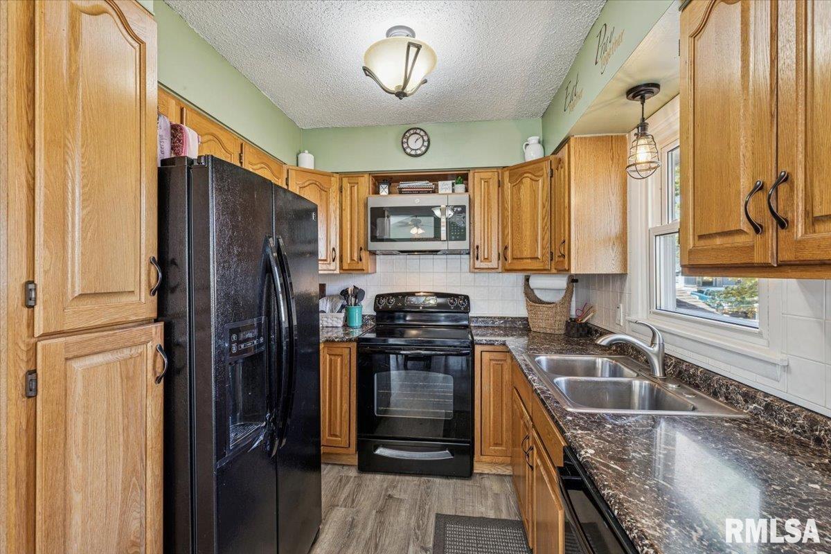 1146 6th Avenue North Clinton, IA 52732 - Photo 13 of 27 a kitchen with a refrigerator a sink and cabinets