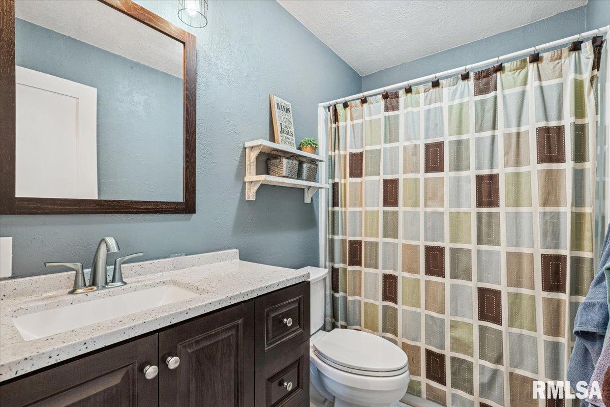 1146 6th Avenue North Clinton, IA 52732 - Photo 20 of 27 a bathroom with a granite countertop sink a toilet and a shower