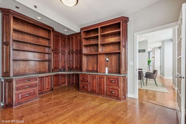 a view of an empty room with furniture and wooden floor
