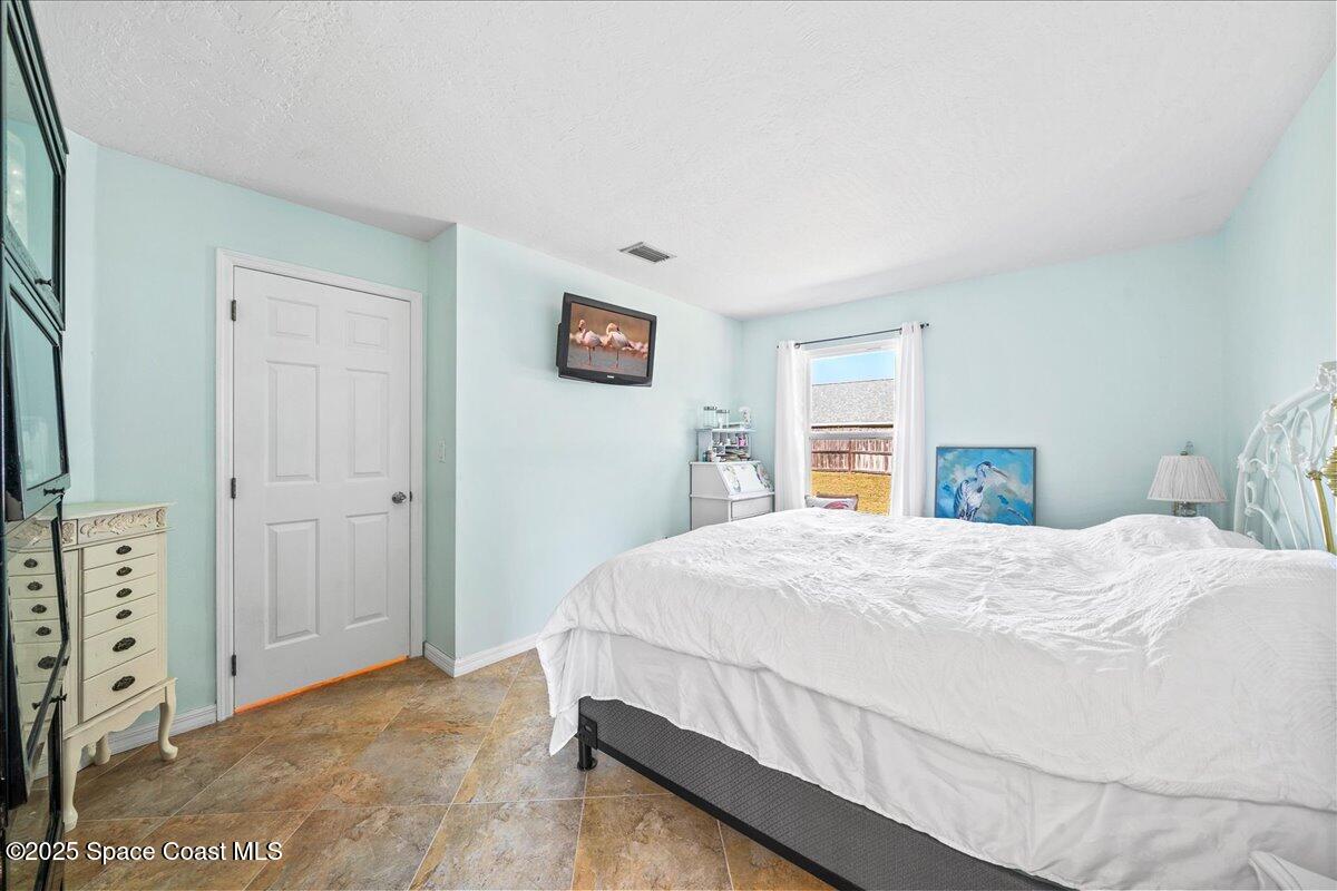 910 Brookshire Circle Malabar, FL 32950 - Photo 17 of 29 a bedroom with a bed and a tv