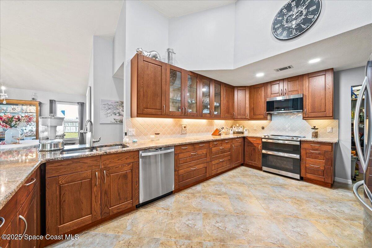 910 Brookshire Circle Malabar, FL 32950 - Photo 8 of 29 a kitchen with stainless steel appliances granite countertop a stove sink and cabinets