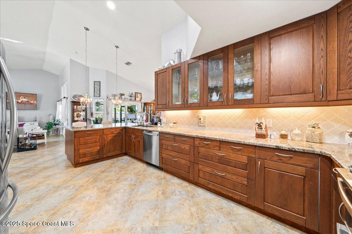 910 Brookshire Circle Malabar, FL 32950 - Photo 9 of 29 a kitchen with granite countertop a sink and dishwasher cabinets with wooden floor