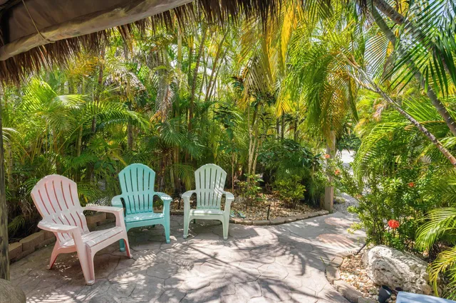 a view of a patio with a table and chairs under an umbrella with a small yard