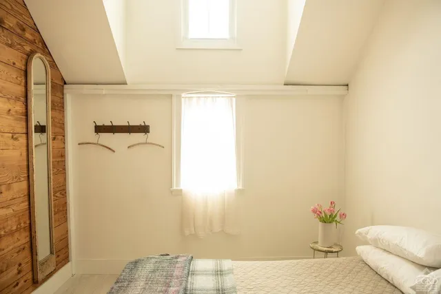 a bedroom with a bed and a painting on the wall