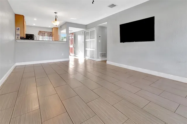 a view of a living room with kitchen view and a flat screen tv