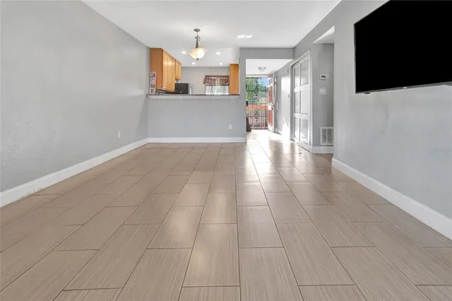 an empty room with windows and a ceiling fan