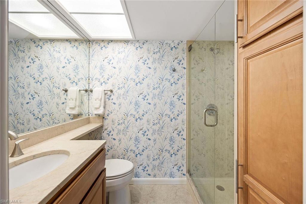 45 High Point Circle South, Unit 303 Naples, FL 34103 - Photo 14 of 22 a bathroom with a sink a toilet and shower