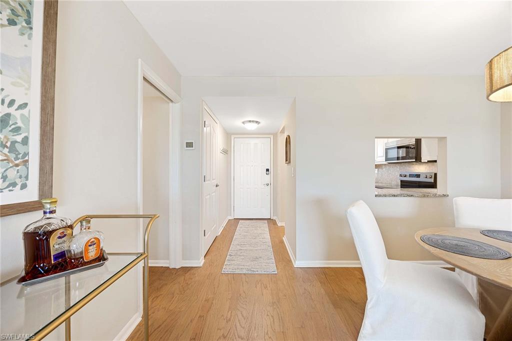 45 High Point Circle South, Unit 303 Naples, FL 34103 - Photo 2 of 22 a dining room with furniture and wooden floor