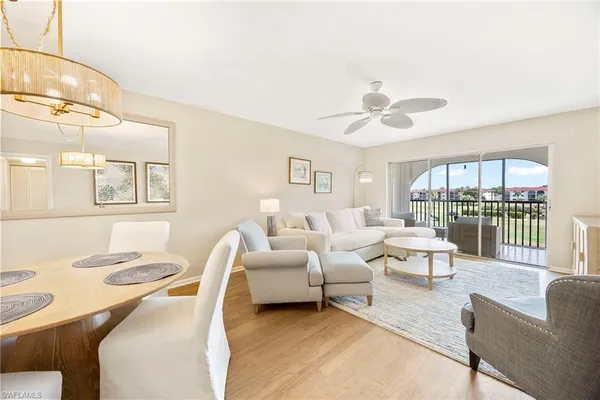 a living room with furniture a chandelier and a table