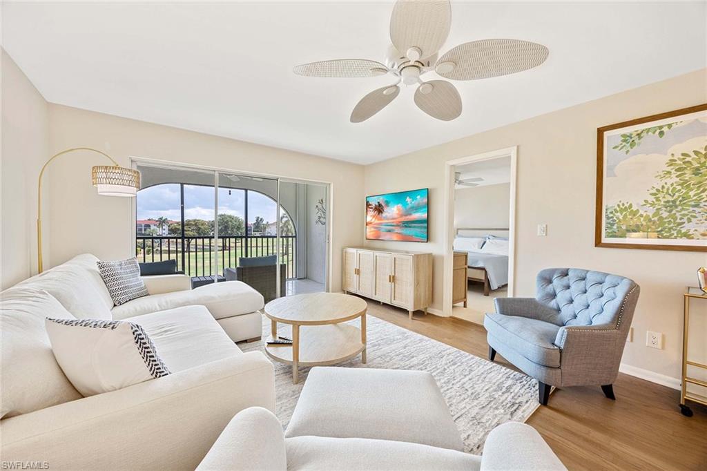 45 High Point Circle South, Unit 303 Naples, FL 34103 - Photo 4 of 22 a living room with furniture and a large window