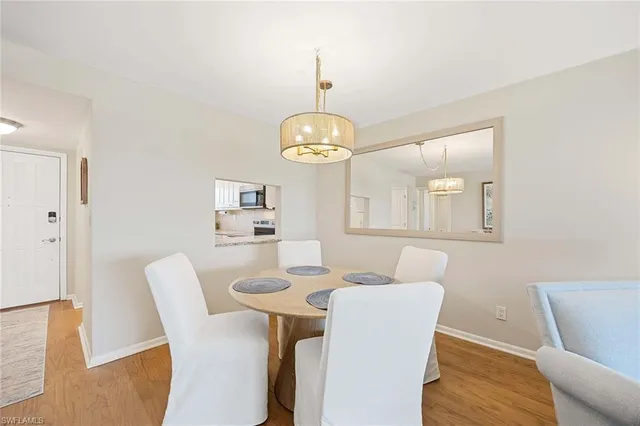 a dining room with furniture a chandelier and wooden floor