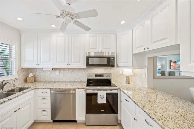 a kitchen with white cabinets and appliances