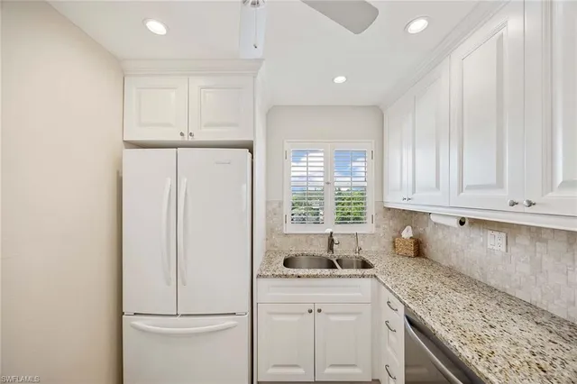 a kitchen with white cabinets and white appliances