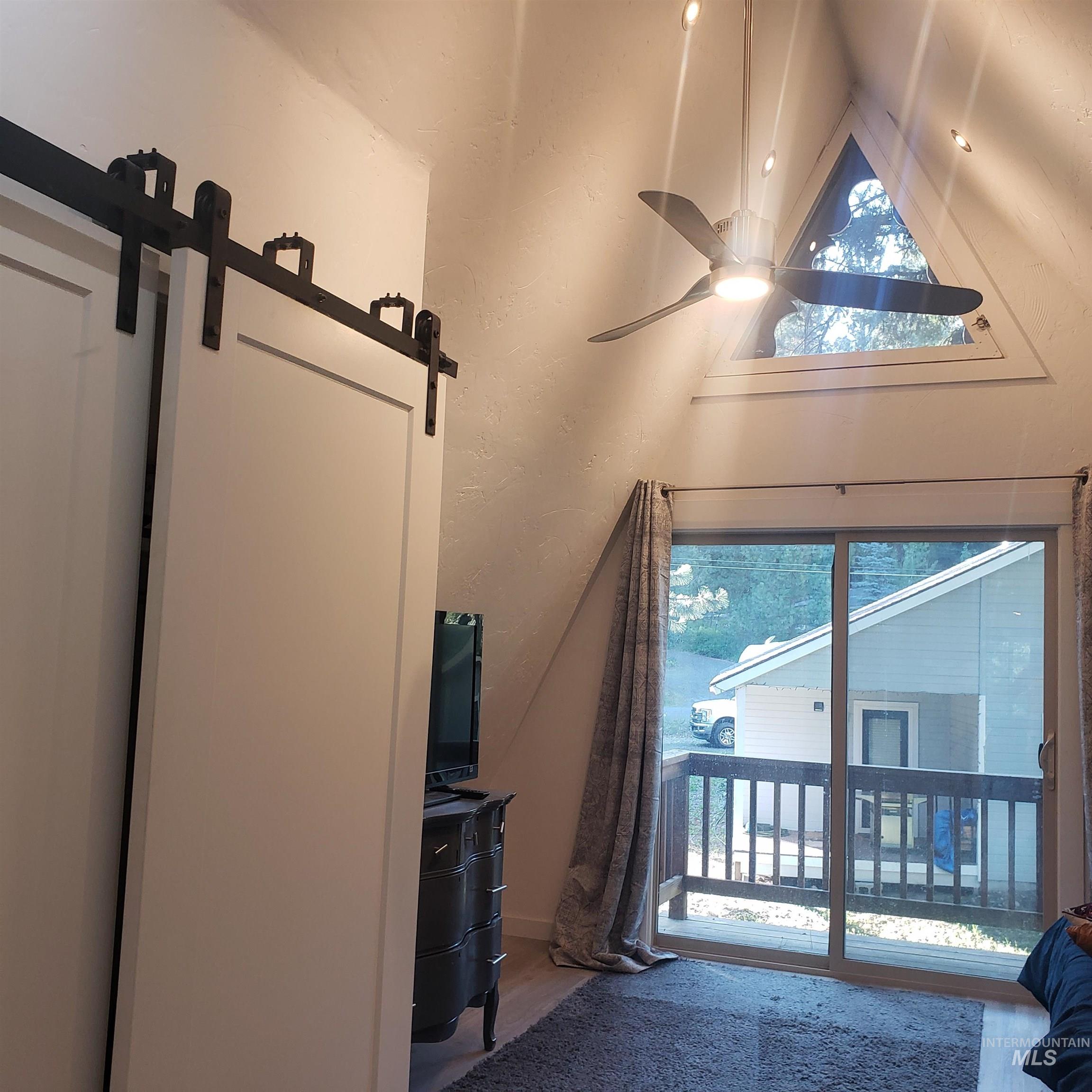 1098 Crescent Rim Drive McCall, ID 83638 - Photo 27 of 42 Doorway with ceiling fan, wood finished floors, a textured wall, and vaulted ceiling