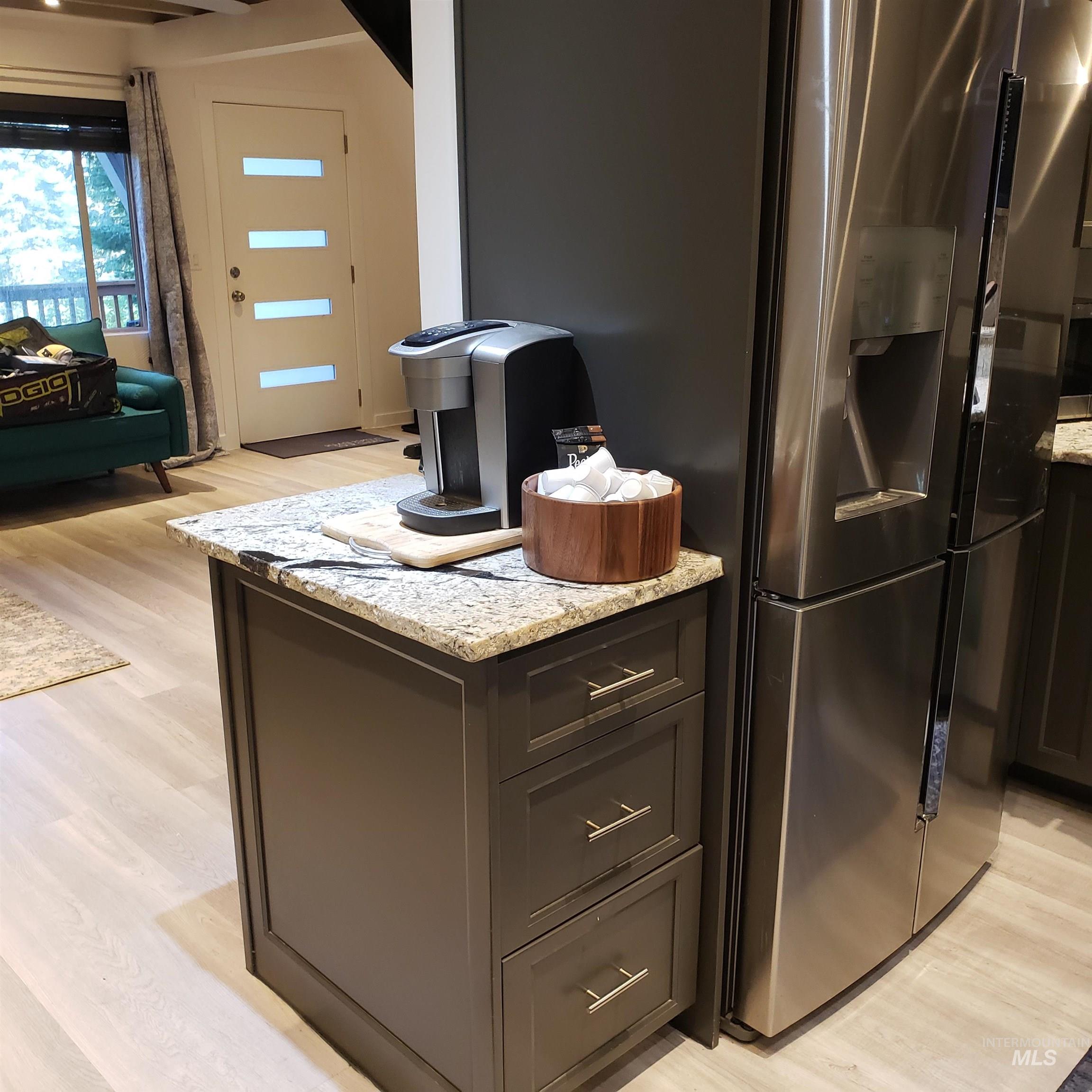 1098 Crescent Rim Drive McCall, ID 83638 - Photo 42 of 42 Kitchen with light wood-style floors, light stone countertops, stainless steel refrigerator with ice dispenser, and open floor plan
