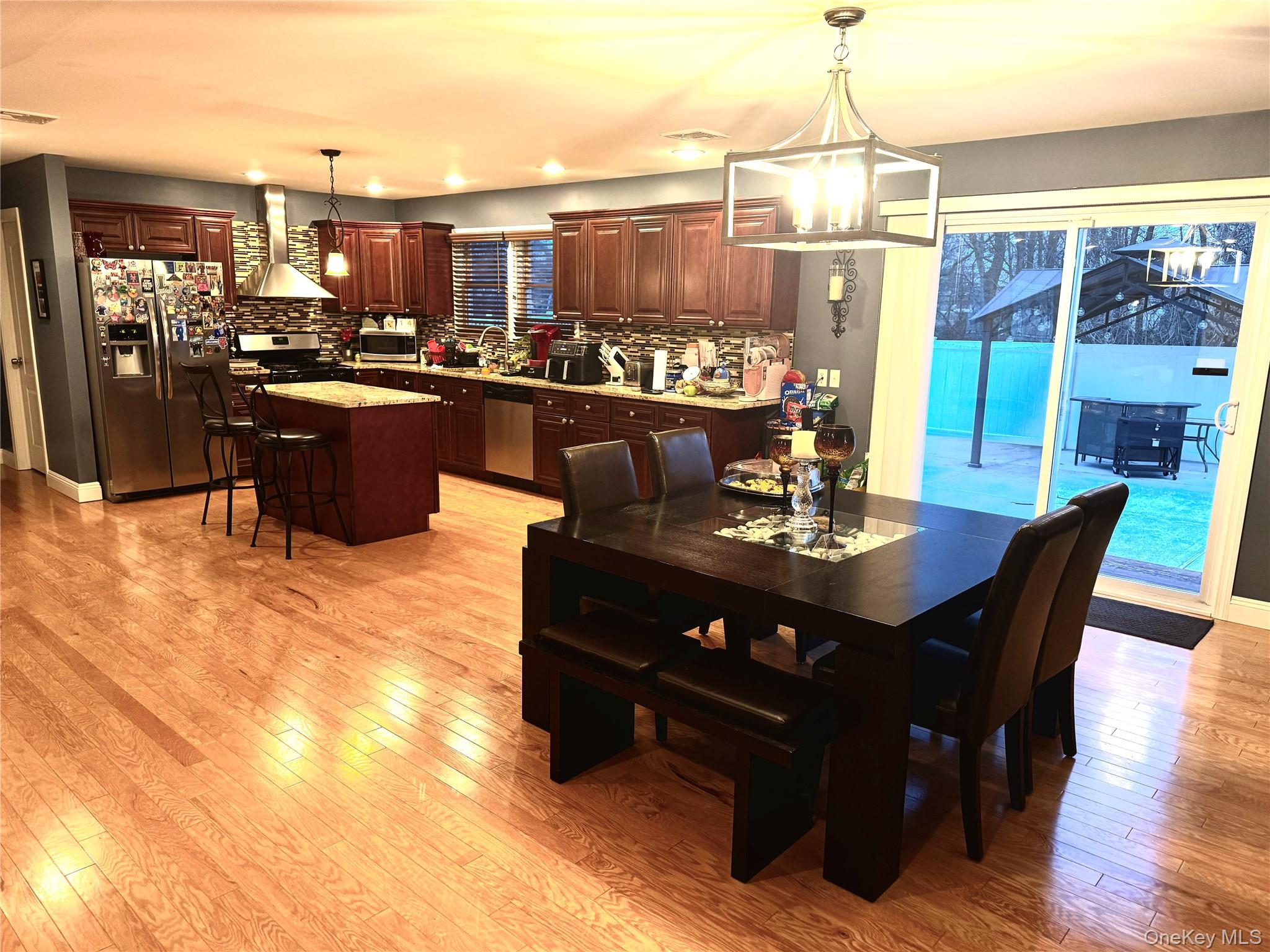 285 Daniel Street Lindenhurst, NY 11757 - Photo 8 of 15 a living room with stainless steel appliances kitchen island granite countertop a table chairs and a kitchen view
