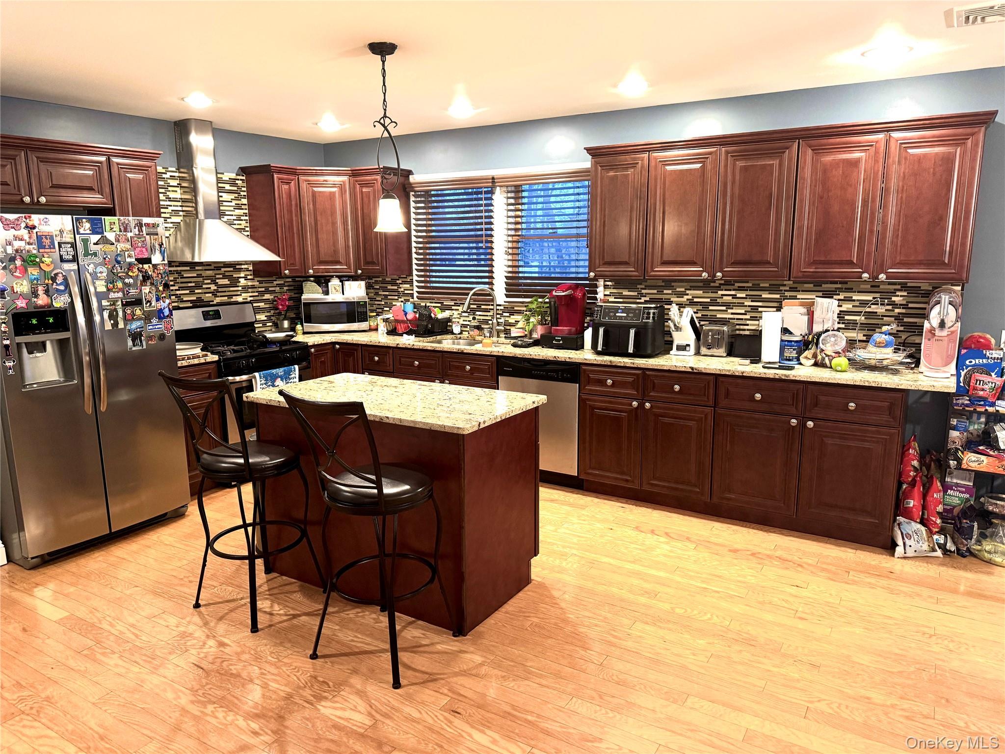 285 Daniel Street Lindenhurst, NY 11757 - Photo 9 of 15 a kitchen with stainless steel appliances granite countertop a table chairs sink and cabinets