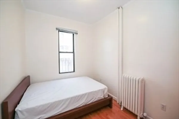 a bed sitting in a bedroom next to a window