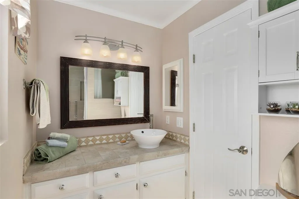 864 E Avenue Coronado, CA 92118 - Photo 12 of 20 a bathroom with a sink and a mirror