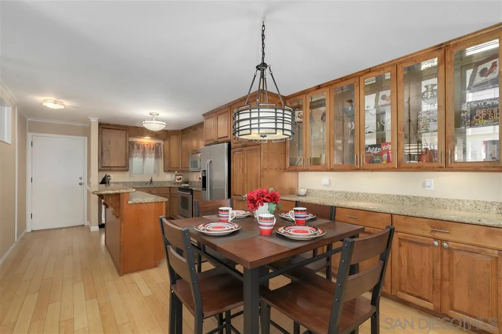 864 E Avenue Coronado, CA 92118 - Photo 6 of 20 a view of a dining room and livingroom with furniture wooden floor a rug a flat screen tv a rug and a chandelier