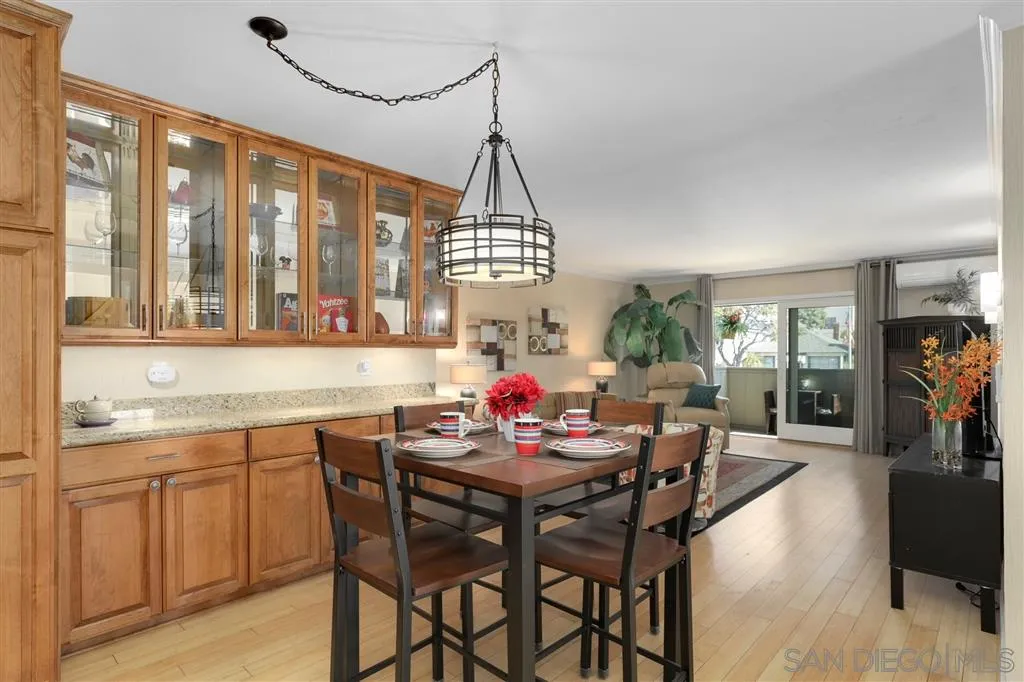 864 E Avenue Coronado, CA 92118 - Photo 10 of 20 a dining room with furniture a chandelier and wooden floor