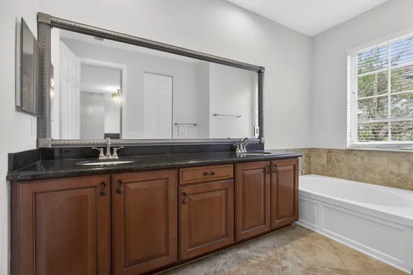 a bathroom with a granite countertop sink mirror vanity and toilet