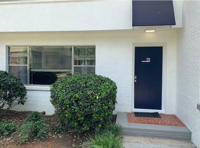 2230 Cheshire Bridge Road Northeast, Unit 111 Atlanta, GA 30324 - Photo 1 of 1 a front view of a house with a yard and garage