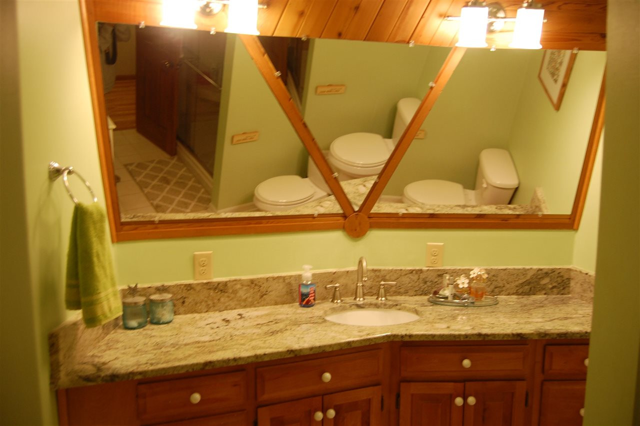 1121 Batchelor Road Apex, NC 27523 - Photo 16 of 30 Master Bath w/granite counter top, tile flooring, Linen closet, shiplap & triple mirror wall behind counter top to ceiling, step-in-shower w/big built-in-bench, 4 level built-in-shelf, & rain head style shower head! Master Bath