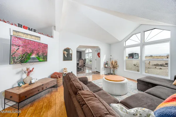 a living room with furniture a flat screen tv and a floor to ceiling window