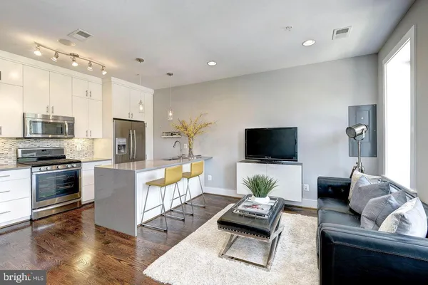 a kitchen with kitchen island a stove cabinets and microwave