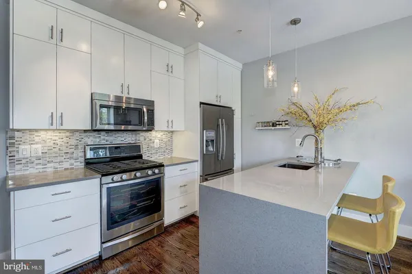 a kitchen with stainless steel appliances granite countertop a sink refrigerator and cabinets