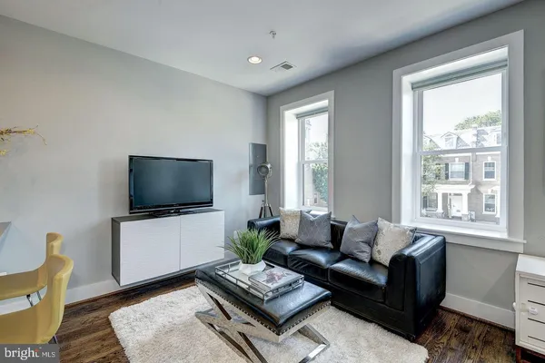 a living room with furniture kitchen view and a flat screen tv
