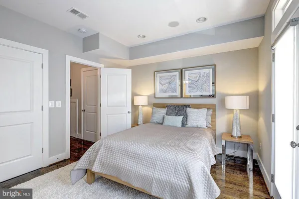 a spacious bedroom with a bed and a dresser