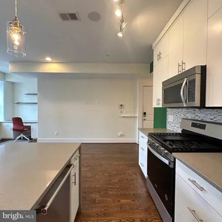 a kitchen with stainless steel appliances a stove microwave and cabinets