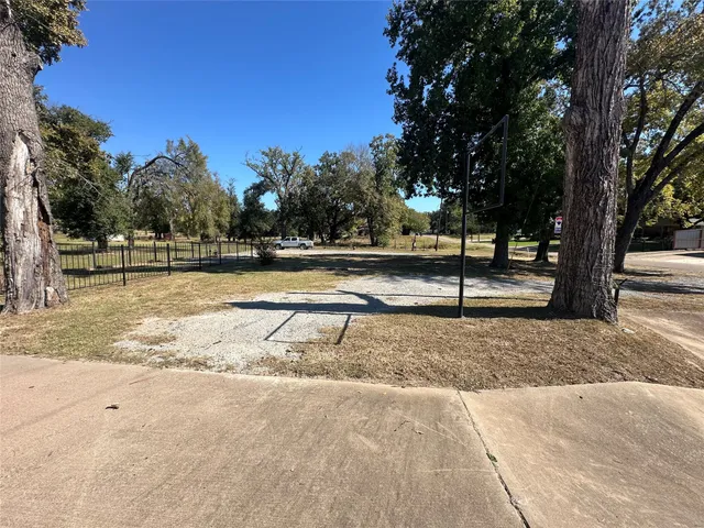 a view of yard with wooden fence and trees
