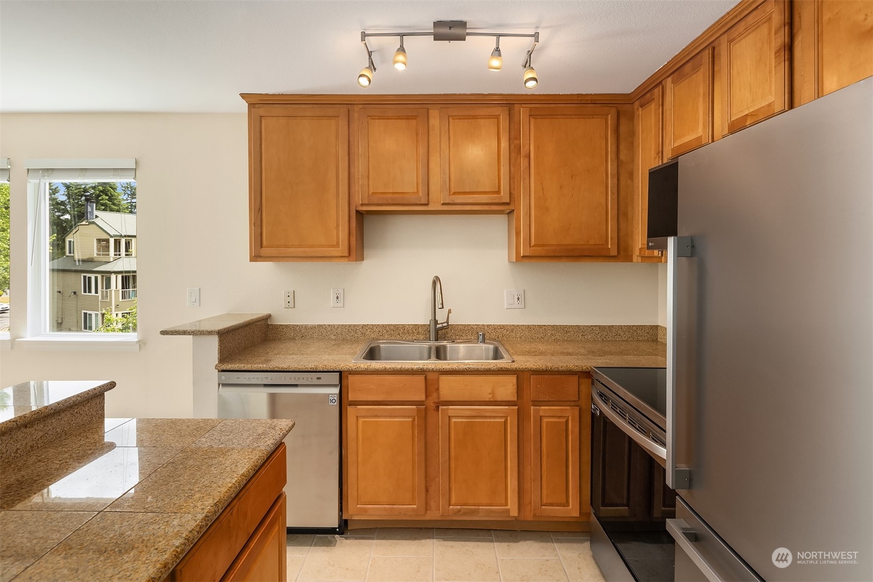 20320 Bothell Everett Highway, Unit D304 Bothell, WA 98012 - Photo 3 of 21 a kitchen with kitchen island granite countertop a sink stove and refrigerator