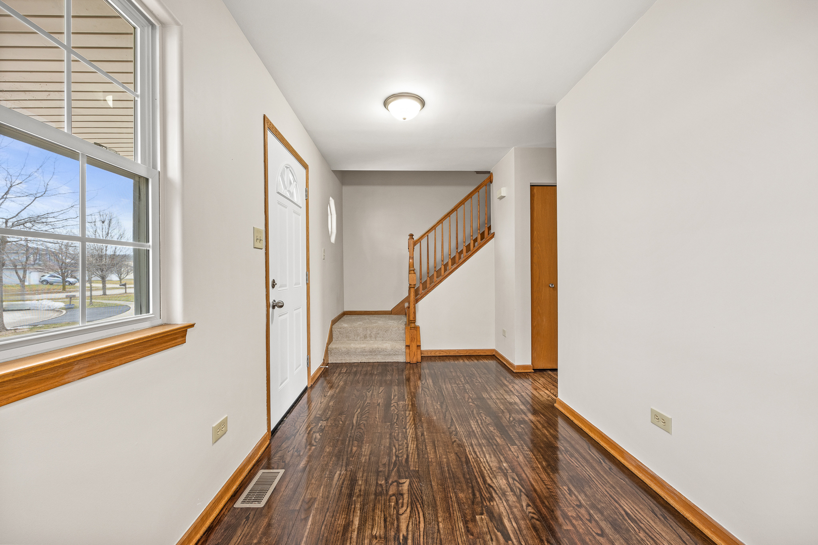 25210 Plainview Drive Channahon, IL 60410 - Photo 3 of 33 a view of a hallway with wooden floor and staircase