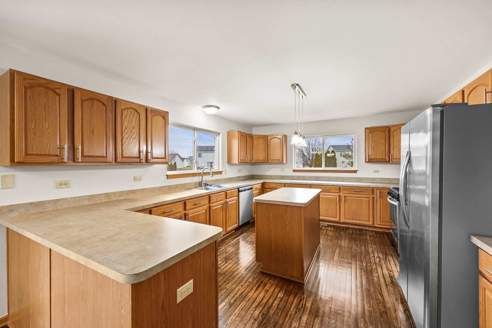 25210 Plainview Drive Channahon, IL 60410 - Photo 6 of 33 a kitchen with stainless steel appliances granite countertop a refrigerator a sink dishwasher a stove with wooden cabinets and floor