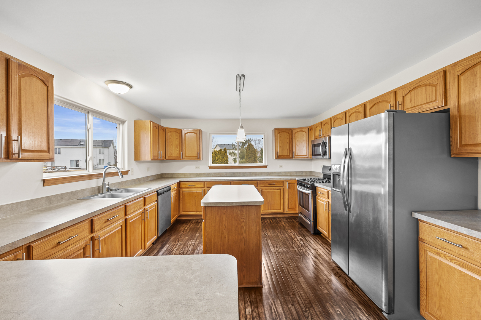 25210 Plainview Drive Channahon, IL 60410 - Photo 7 of 33 a kitchen with stainless steel appliances granite countertop a refrigerator a sink dishwasher a stove and a dining table with wooden floor