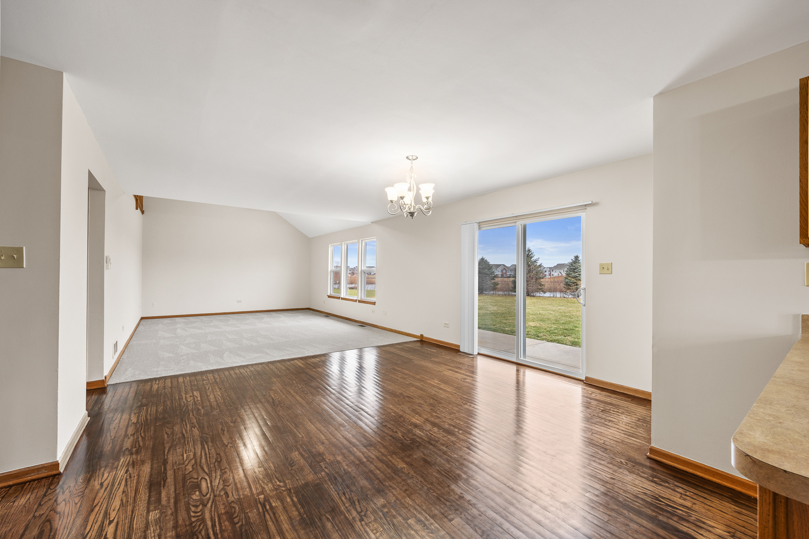 25210 Plainview Drive Channahon, IL 60410 - Photo 10 of 33 an empty room with wooden floor chandelier and windows