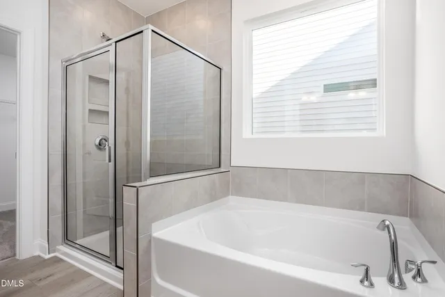 a white bath tub sitting next to a shower