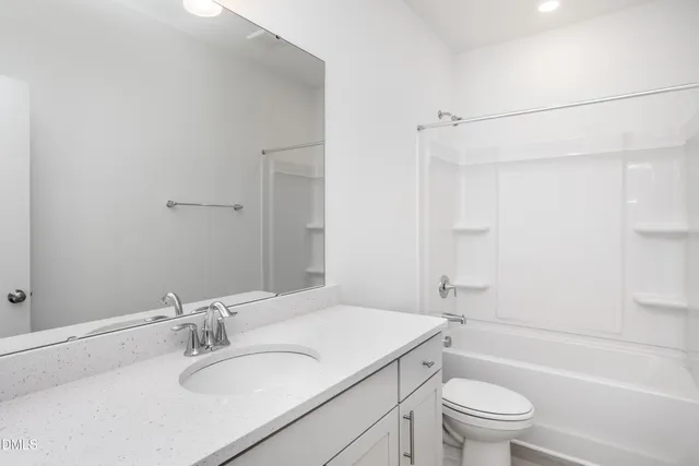 a bathroom with a granite countertop sink a toilet and shower