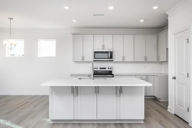 a kitchen with a sink a microwave a stove and cabinets