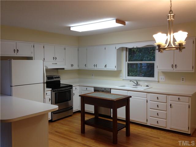 1901 Fountain Ridge Road Chapel Hill, NC 27517 - Photo 3 of 7 a kitchen with a table chairs stove and cabinets