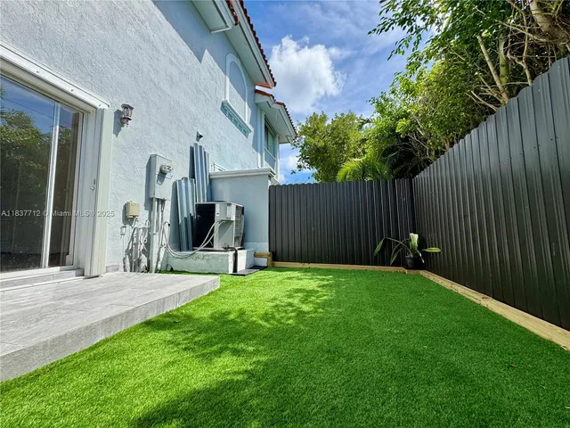 a view of a house with backyard and a tree