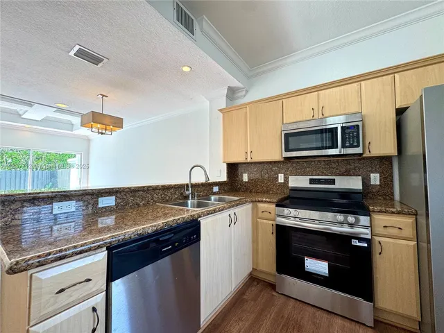 a bedroom with a bed and dresser with wooden floor
