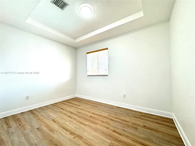 a view of a room with wooden floor and window