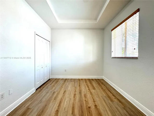 a view of a room with wooden floor and window