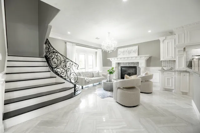a living room with furniture a fireplace and a chandelier