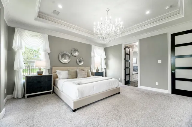 a bedroom with a bed and a chandelier